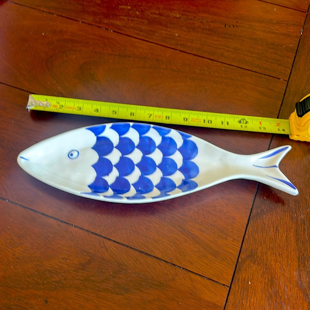 Small white with blue scales fish shaped hors d’oeuvres dish.